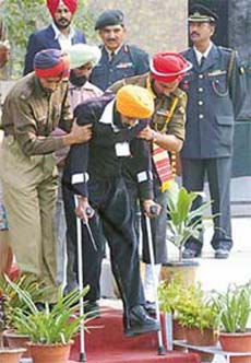 Army personnel help a disabled ex-serviceman after he received a grant from the Chief Minister during the ex-servicemen rally at Amritsar