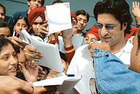 Former Pakistan Test player Wasim Akram signs autographs after sharing his experiences on diabetes with students at Shivalik Public School, Mohali