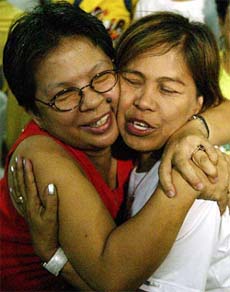 Nicole Daniel is hugged by a neighbour of Philippine UN diplomat, Angelito Nayan, as they celebrate during a thanksgiving mass for the release of Nayan by Afghan abductors