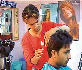 A file picture of Nadeem Ahmed ‘cutting’ hair with a candle