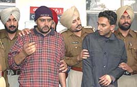 Former Punjab Police constable Ranjit Singh (wearing cap) and his accomplice being 