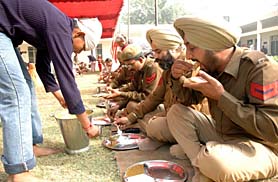 Policemen partake of langar organised in connection with the martyrdom day of Guru Tegh Bahadur in Ludhiana on Wednesday