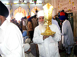 Baba Jagtar Singh of Jeevan Singh Karsevawale from Tarn Taran holds the gold-plated khanda at Gurdwara Nankana Sahib