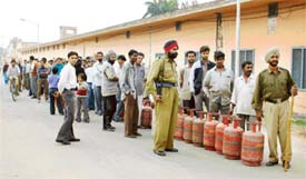 Consumers queue up to receive LPG refills under police supervision in Ahmedgarh