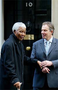 Britain's Prime Minister Tony Blair assists South Africa's former President Nelson Mandela on the steps of 10 Downing Street as they bid each other farewell in London