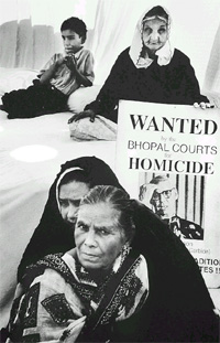 Wanted for homicide: Survivors display a poster calling for the extradition of Warren Anderson, former Chief Executive of Union Carbide, from the US. Many protesters are women who lost their husbands and children in the tragedy.