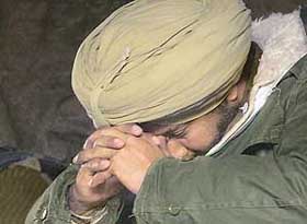 A CRPF jawan grieves near the body of his colleague at the police control room in Srinagar on Sunday