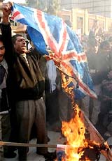 Iranian men burn a British flag outside the British Embassy in Teheran on Monday