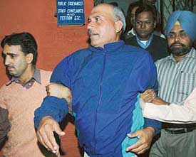 Chandigarh Police Sub-Inspector Rajpal Singh being taken out from Sector 31 police station by CBI officials in Chandigarh