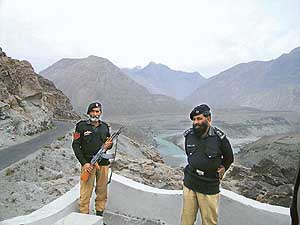 Pakistani security personnel guarding the mountain ranges. Behind them is the Karakoram range and to their left is the Hindu Kush. They face the Himalayas (not seen in the picture). Also can be seen the Karakoram highway that links Pakistan with China and the confluence of the Indus and the Hunza. 