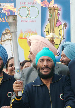 Flying Sikh Milkha Singh holds the torch at the Wagah checkpost as he is all set to begin the relay for the Indo-Pak Punjab Games on Thursday