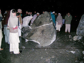 Indian and Pakistani journalists give a helping hand to push a boulder off the Karakoram Highway.