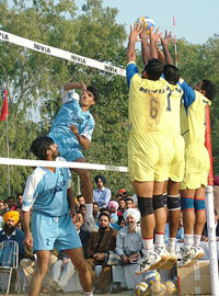 Players of the Punjab team try to block a smash from a Pakistan Punjab player during a volleyball match in Amritsar