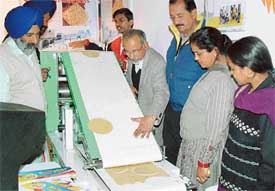 Manufacturers of the readymade chapati-making machine, the first of its kind in India, hold a demonstration for visitors to Agro-Tech, which concluded on Monday