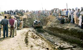 Villagers watch as a tractor moves earth from the spot where two labourers were buried at Seeolani village near Malerkotla on Monday
