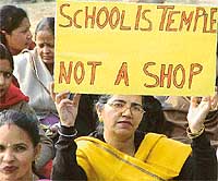 A member of the Association of Private Education Institutions holds a banner during a protest at Matka Chowk in Chandigarh on Tuesday. 