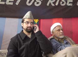 Moulvi Umar Farooq (left), chairman, All-party Hurriyat Conference, speaks on phone as Moulvi Abbas Ansari (right) looks on during a day-long relay fast in Srinagar on Tuesday.