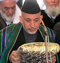 Afghan President Hamid Karzai holds the Holy Qoran as he is sworn in as Afghanistan's first popularly elected president at a ceremony in Kabul's Presidential Palace 