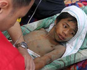 Filipino flood survivor Ian Carl Bungadin is given first aid in the town of Real, Quezon province