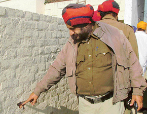 A police officer shows bullet marks on a wall at Matour village in Mohali on Friday.
