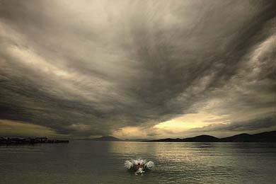 A winter swimmer dives in the calm waters of the Pagasitikos bay
