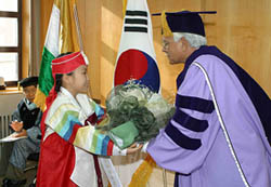 External Affairs Minister K. Natwar Singh receives a bouquet from a girl wearing a traditional costume before Kuyng Hee University conferred an honorary doctorate degree on him in Seoul on Thursday. 