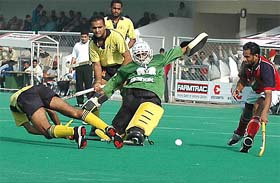 Punjab & Sind Bank players try to get past the Punjab Police defence on the first day of the All-India Ramesh Chander Memorial Hockey Tournament in Jalandhar