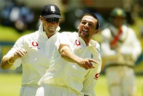 England's bowler Stephen Harmison celebrates with his teammate Marcus Trescothick