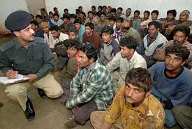 A Pakistani police officer checks the list of the detained Indian fishermen