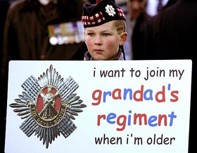 A young boy shows his opposition to the British government's proposed merger of Scottish army regiments into the new multi-battalion Royal Regiment of Scotland in Edinburgh on Saturday. Hundreds of protestors marched against the merger.