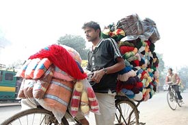A vendor carries woollen material on his bicycle in Allahabad on Monday as winter grips the countrys northern parts.