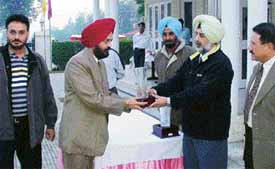 Dr G.S. Aujla, Director, Punjab Police, Academy, Phillaur, presents a trophy to a winner of the PGA Guru Teg Bahadur Inter-Club Golf Championship held at Phillaur