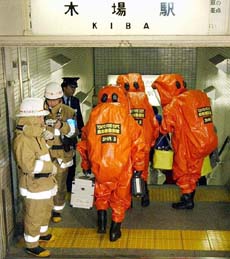 Firefighters in protective suits enter a Tokyo subway station where a liquid chemical was spread in a train car on Sunday.