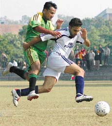 AG, Haryana, and AG, Punjab, players fight to get the ball during a football match in Chandigarh