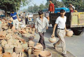Potters carry their ware as the Municipal Corporation launches anti-encroachment drive at the dividing roads of Sectors 24 and 25, Chandigarh
