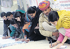 Pedestrians at Parliament Street viewing the signatures and banners which were displayed by various NGOs and political organisations during a dharna near Parliament on Tuesday. They are demanding immediate enactment of a National Rural Employment Guarantee Act. 