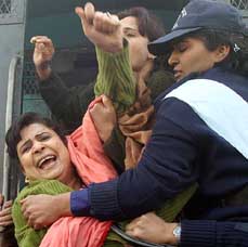 A woman supporter of Pakistan Peoples Party raises slogans while being arrested at Islamabad airport on Tuesday. Pakistani police re-arrested the husband of former Prime Minister Benazir Bhutto, Asif Ali Zardari, on Tuesday, less than a month after his release from jail.