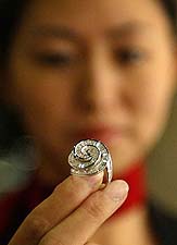 A Chinese saleswoman displays a unique diamond ring worth $ 10,400 at a diamond store in Beijing on Wednesday.
