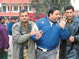 A person, who sold forms on the black market at a khula darbar, being taken away by the police
