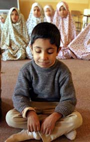 A young Iraqi orphan leads orphan girls during evening prayers 