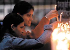 Girls lighting candles on the eve of Xmas at a church in the Capital