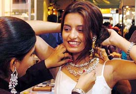 A girl tries a necklace from a new line of jewellery inspired by the blockbuster, Mughal-e-Azam, being exhibited at a stall during a jewellery exhibition in New Delhi on Saturday.