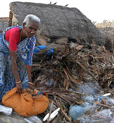 A woman collects belongings from her damaged hut after a tsunami hit Chennai on December 26.  Reuters