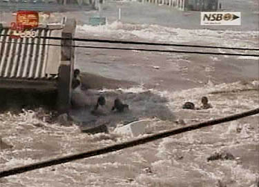 A frame grab taken from an SLRC video footage shows people desperately trying to escape flood water by clinging on to a building on the east coast of Sri Lanka on December 26. The worst tsunami in living memory swamped Sri Lanka's south and east, killing nearly 2,500 persons on Sunday morning.  Reuters