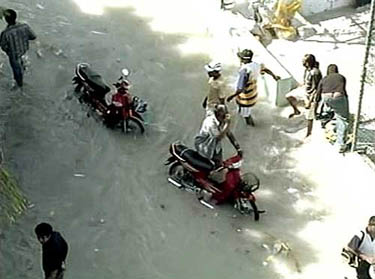 Residents of Maldives wade through a flooded street after a series of tsunami waves hit the popular holiday destination on December 26.  Reuters