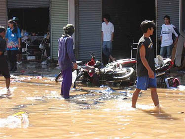 Residents walk in ankle-deep water after a tsunami hit the entertainment district of Patong in Phuket, Thailand, on December 26.  Reuters