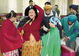 A BJP councillor, Ms Kamla Sharma, being led outside the House by marshals during the MC meeting