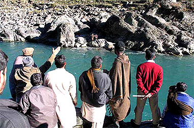 Pakistani Kashmiris in the foreground communicate with their Indian relatives across the Neelum river in the Tethwal sector, 60 km north-east of Muzaffarabad