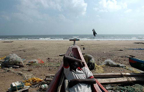 A fisherman takes rest at Marina beach in Chennai on Monday after search operations at sea.  PTI