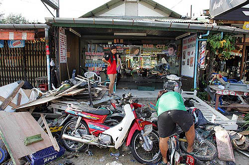 A Thai shop assistant looks at destruction left by a tidal wave at Pathong beach, near Phuket, on December 27.   Reuters
